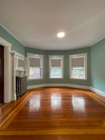 a view of an empty room with window and fire place
