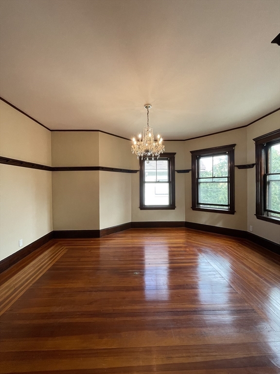 71 Mayfield Street, Unit 2 Boston, MA 02125 - Photo 5 of 33 an empty room with wooden floor and windows