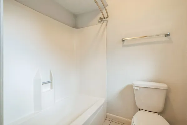 a white toilet sitting next to a bath tub