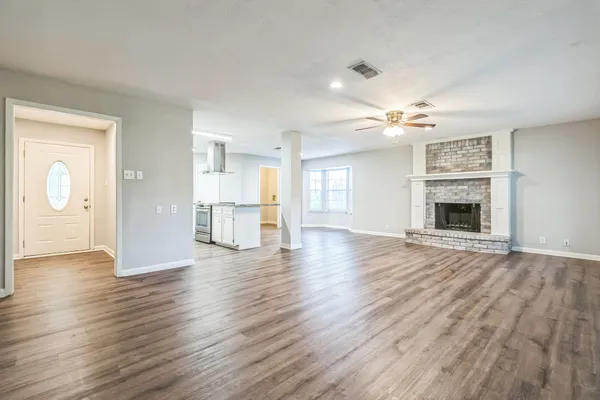 a view of a livingroom with wooden floor and a ceiling fan