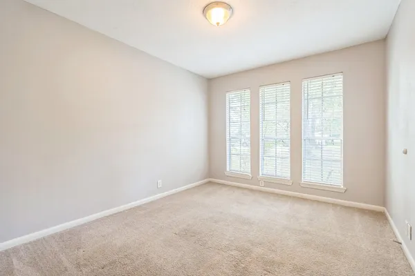 an empty room with windows and closet