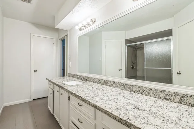 a bathroom with a granite countertop sink and a mirror