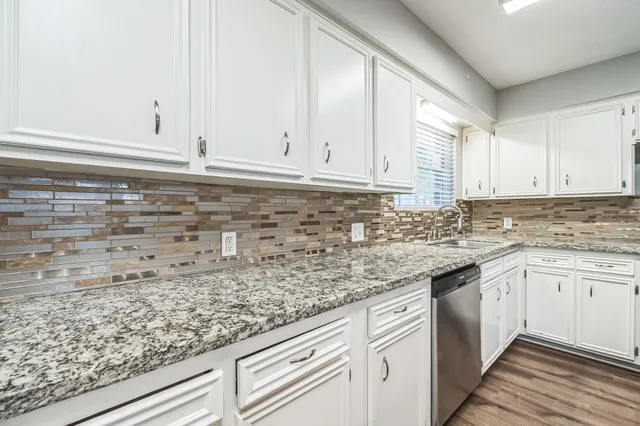 a kitchen with granite countertop white cabinets and white appliances