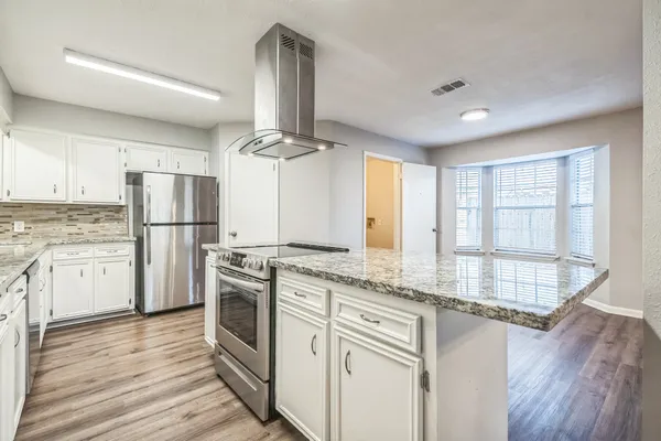 a kitchen with a refrigerator a sink and dishwasher with wooden floor