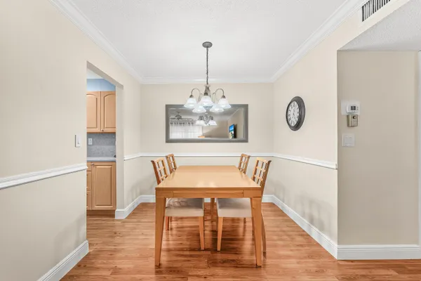 a dining room with furniture a chandelier and wooden floor