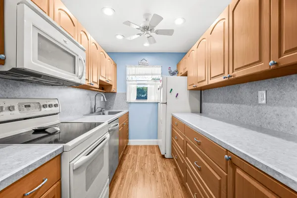 a kitchen with stainless steel appliances granite countertop a sink and dishwasher a stove top oven with wooden floor