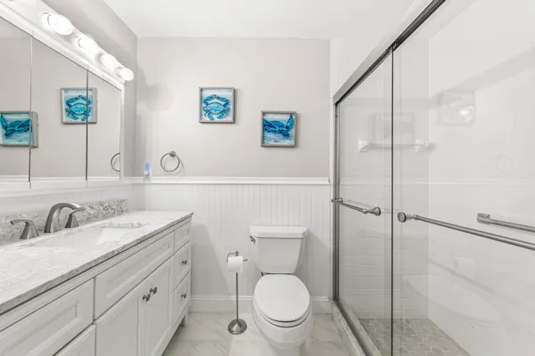 a bathroom with a granite countertop sink mirror vanity and toilet