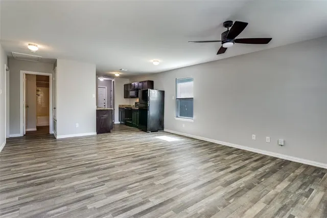 a view of empty room with wooden floor and window