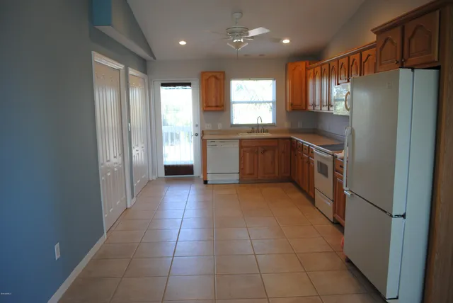 a kitchen with granite countertop a refrigerator and a stove top oven
