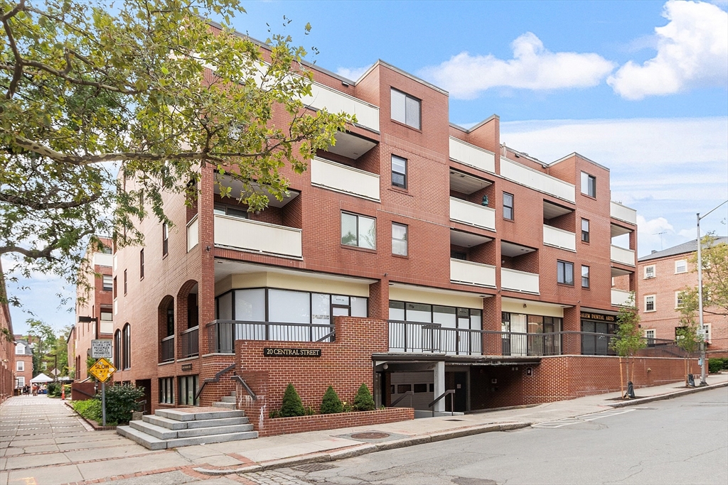 a front view of a multi story residential apartment building with garage and parking space