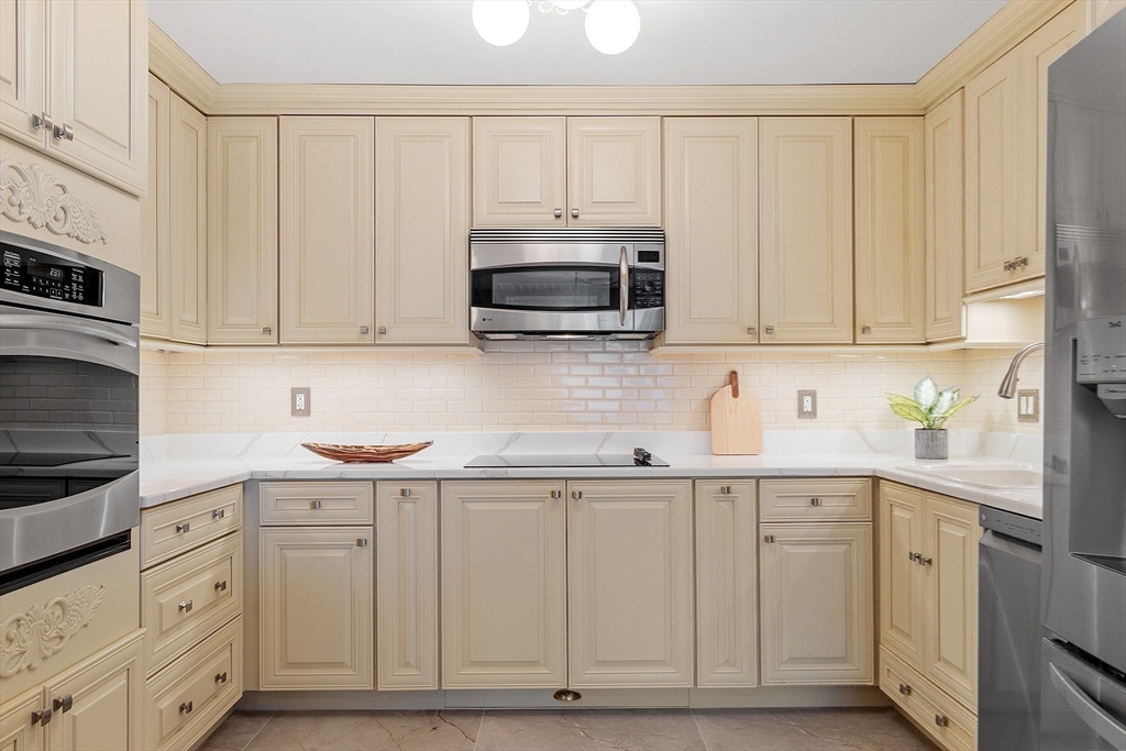 20 Central Street, Unit 402 Salem, MA 01970 - Photo 14 of 36 a kitchen with white cabinets and white appliances