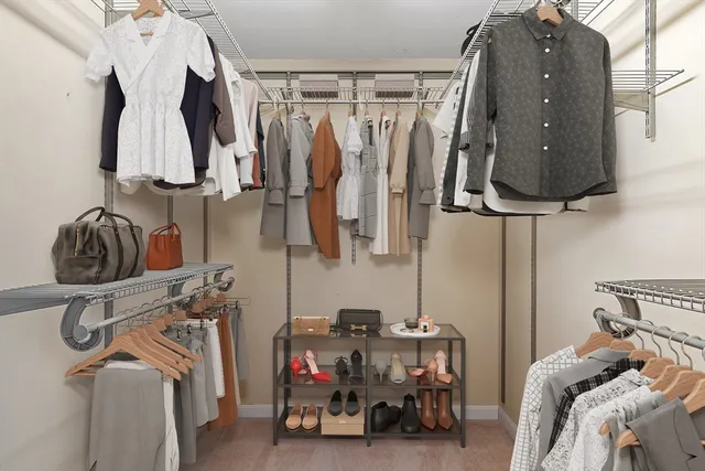 a view of walk in closet with clothes and shoes