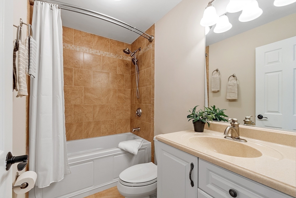 20 Central Street, Unit 402 Salem, MA 01970 - Photo 22 of 36 a bathroom with a granite countertop sink toilet mirror vanity and shower
