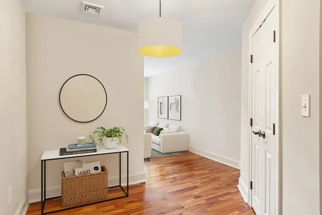 a view of a bedroom with wooden floor and furniture