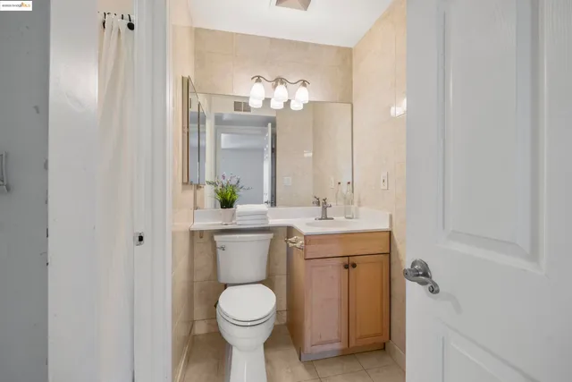 a bathroom with a granite countertop sink toilet and a mirror