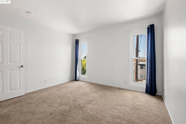 an empty room with window and hallway