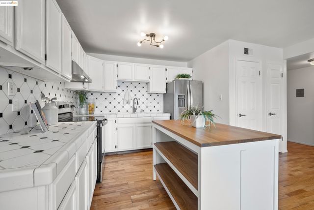 a kitchen with white cabinets sink and white appliances