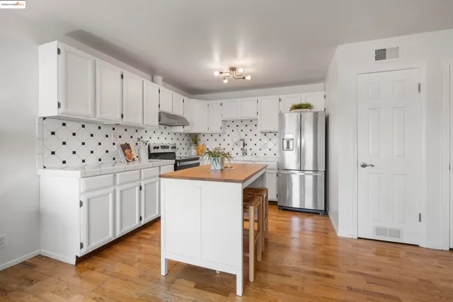 a kitchen with white cabinets and stainless steel appliances