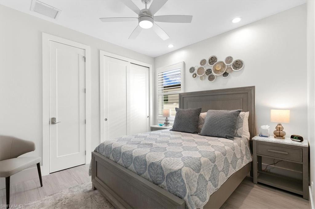 734 109th Avenue North Naples, FL 34108 - Photo 16 of 34 a bedroom with a large bed and a chandelier