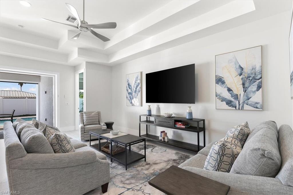 734 109th Avenue North Naples, FL 34108 - Photo 2 of 34 a living room with furniture and a flat screen tv