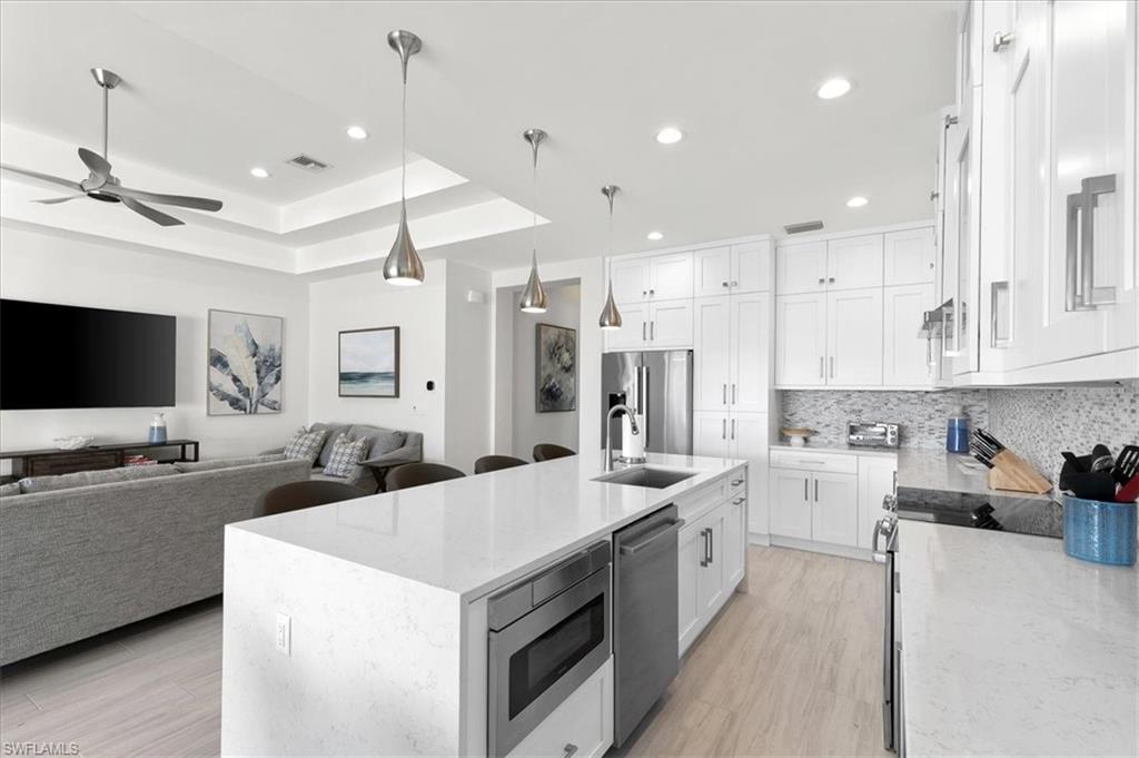 734 109th Avenue North Naples, FL 34108 - Photo 30 of 34 a large white kitchen with a large window a sink and a stove top oven