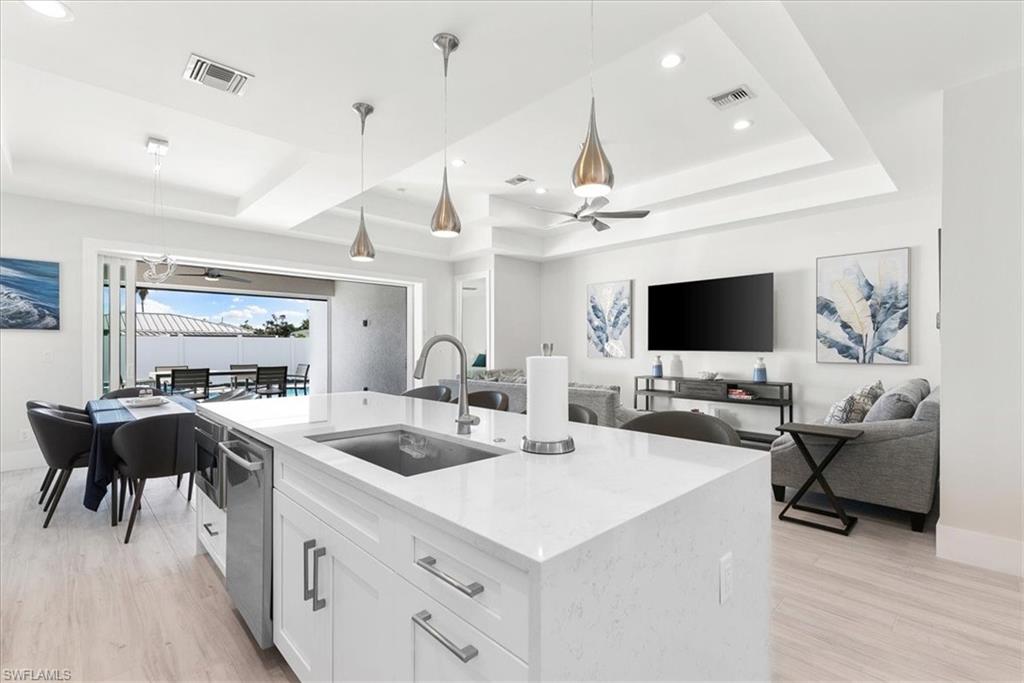 734 109th Avenue North Naples, FL 34108 - Photo 31 of 34 a kitchen with a sink and a stove top oven with wooden floor