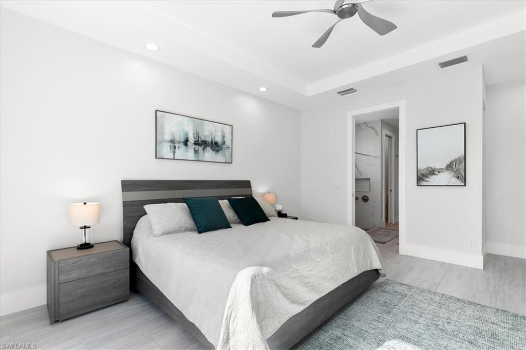 734 109th Avenue North Naples, FL 34108 - Photo 9 of 34 a bedroom with a large bed and a chandelier