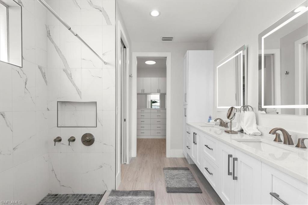 734 109th Avenue North Naples, FL 34108 - Photo 10 of 34 a bathroom with a double vanity sink and mirror