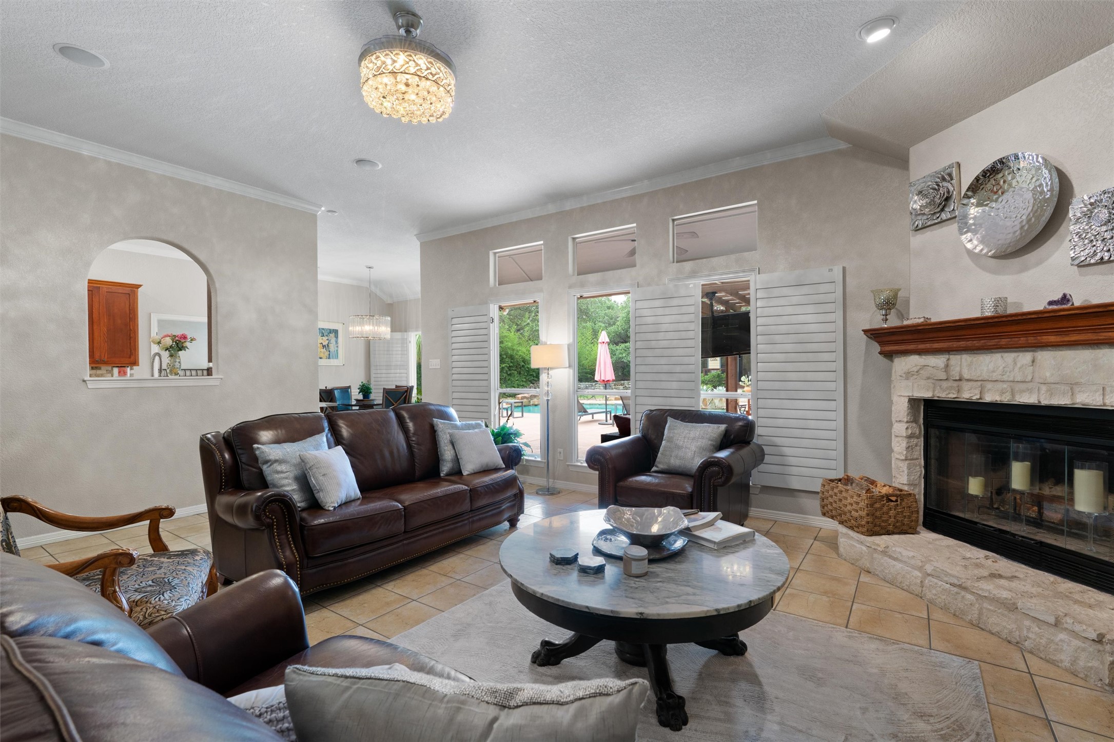 223 East Ridgewood Road Georgetown, TX 78633 - Photo 7 of 40 A fireplace with a stone hearth in the living room offering direct views of the outdoor pool