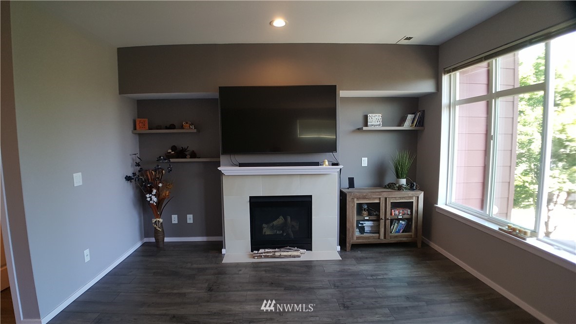 135 Cougar Ridge Road Northwest Issaquah, WA 98027 - Photo 3 of 22 a living room with a fireplace and a flat screen tv
