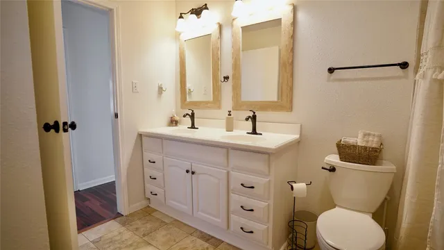 a bathroom with a toilet sink and mirror