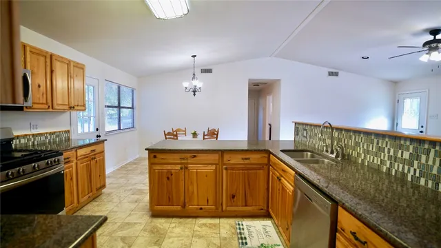 a kitchen with stainless steel appliances granite countertop a stove a sink and a refrigerator
