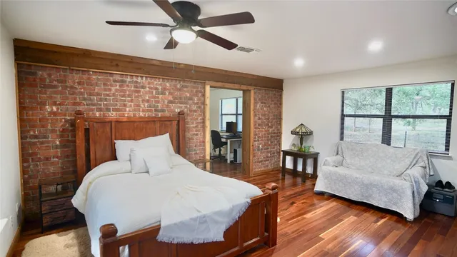 a bedroom with a bed and wooden floor
