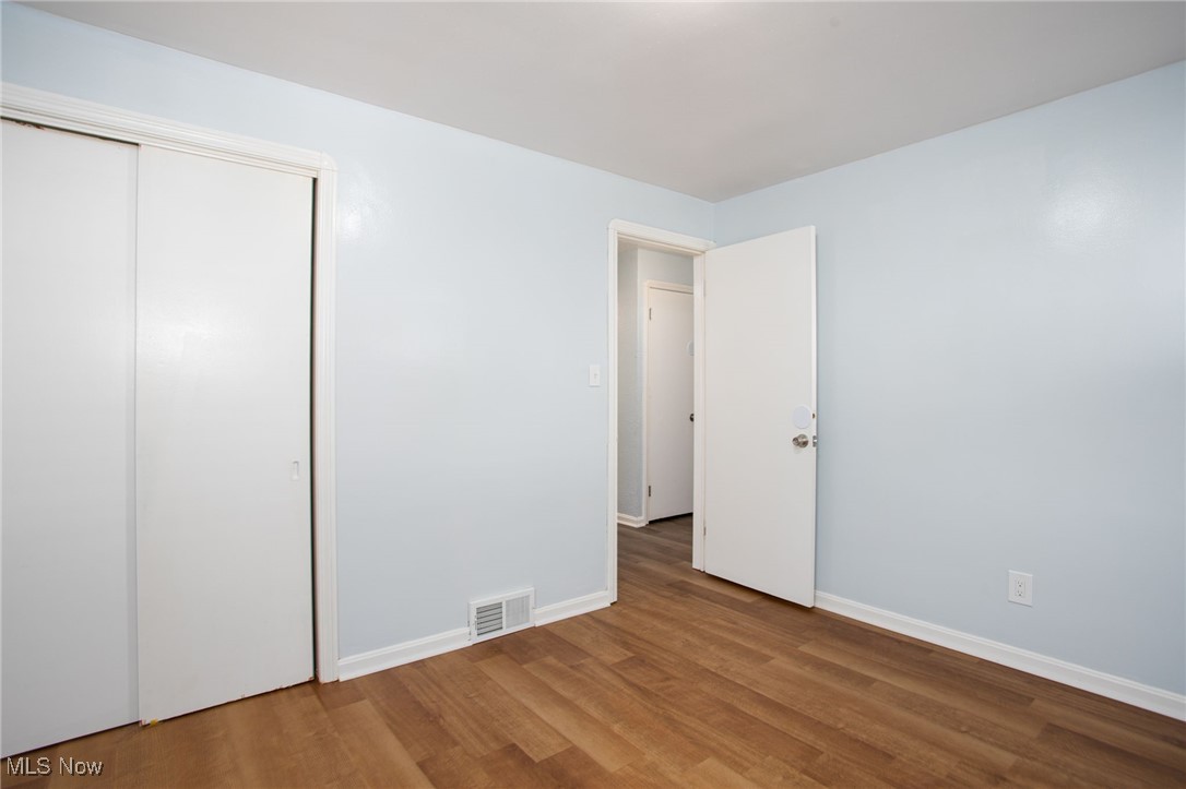 12028 Triskett Road Cleveland, OH 44111 - Photo 15 of 23 Unfurnished bedroom with wood finished floors and a closet