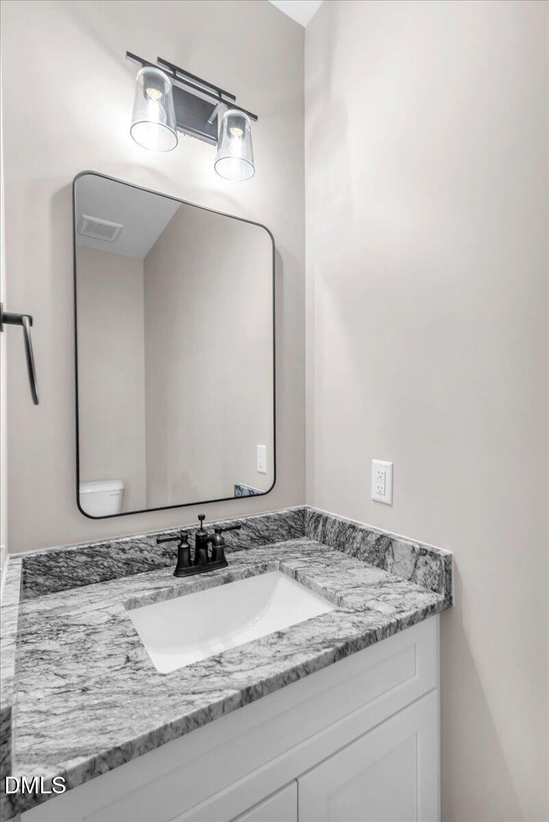 12615 Mallard Rock Drive Zebulon, NC 27597 - Photo 15 of 89 a bathroom with a granite countertop sink and a mirror