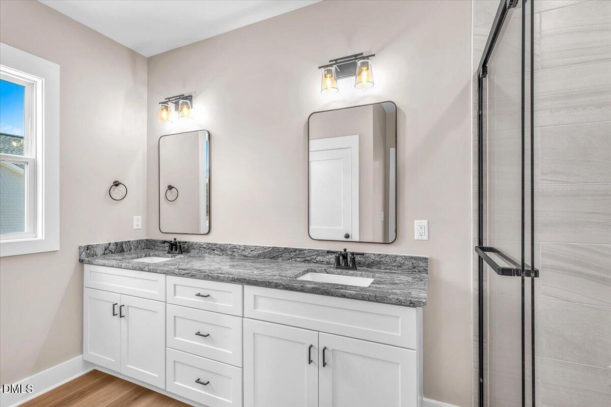 12615 Mallard Rock Drive Zebulon, NC 27597 - Photo 38 of 89 a bathroom with a double vanity sink and a mirror
