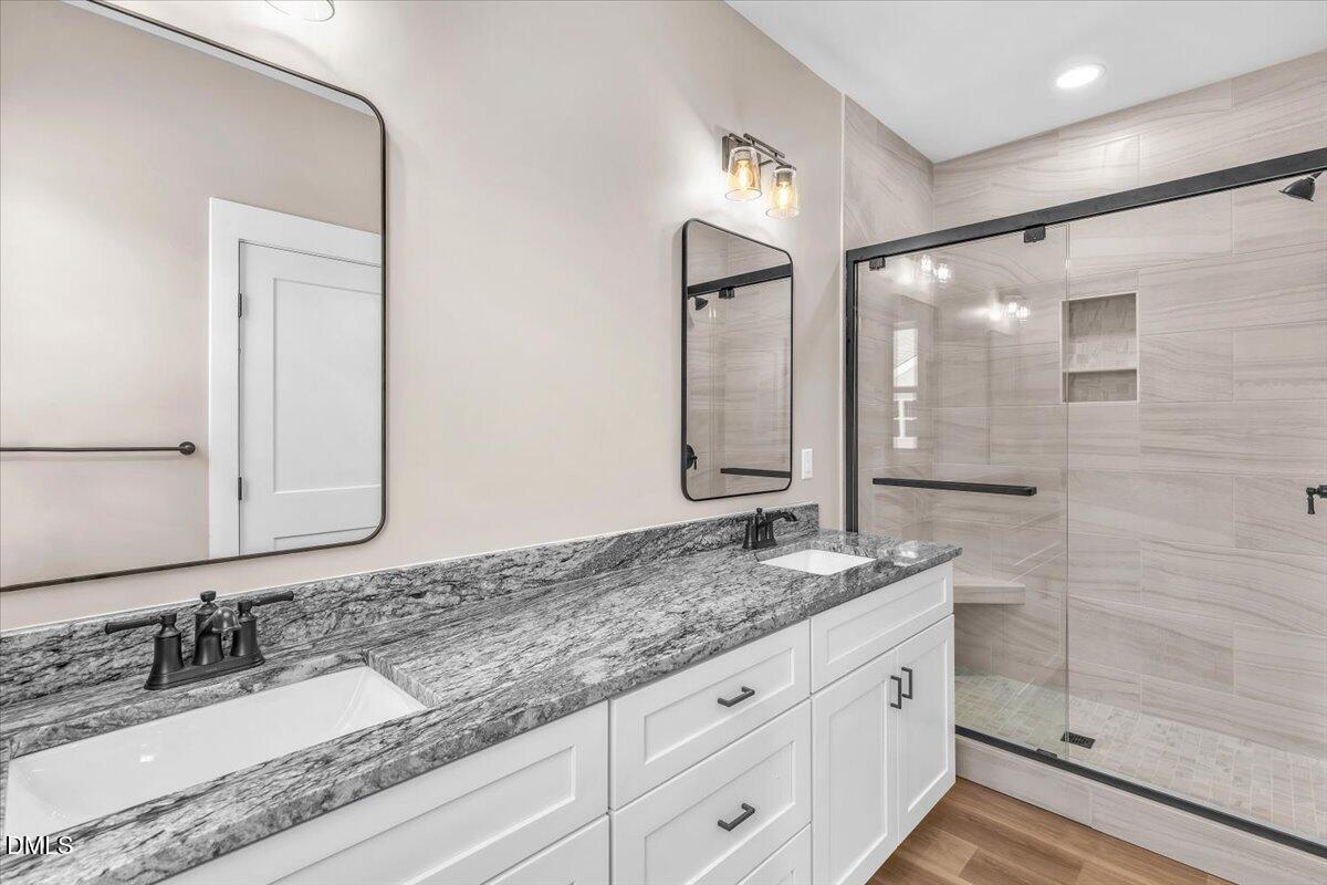 12615 Mallard Rock Drive Zebulon, NC 27597 - Photo 39 of 89 a bathroom with a granite countertop double vanity sink and mirror