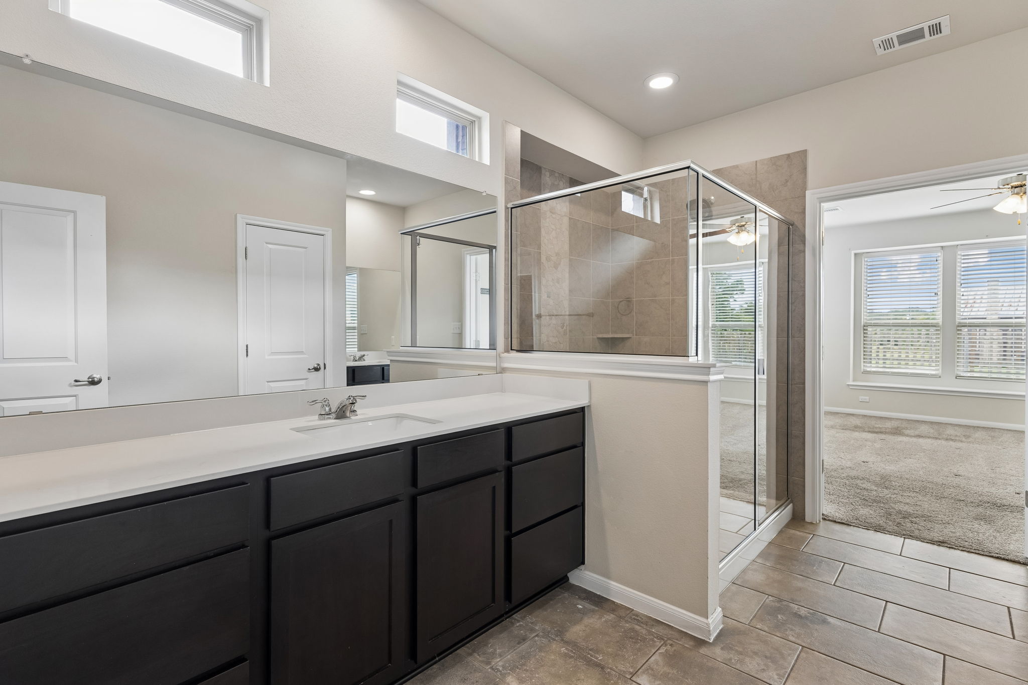 301 Rimrock Court Bastrop, TX 78602 - Photo 14 of 21 A refined primary bathroom features an extensive vanity and a separate glass-enclosed shower area.