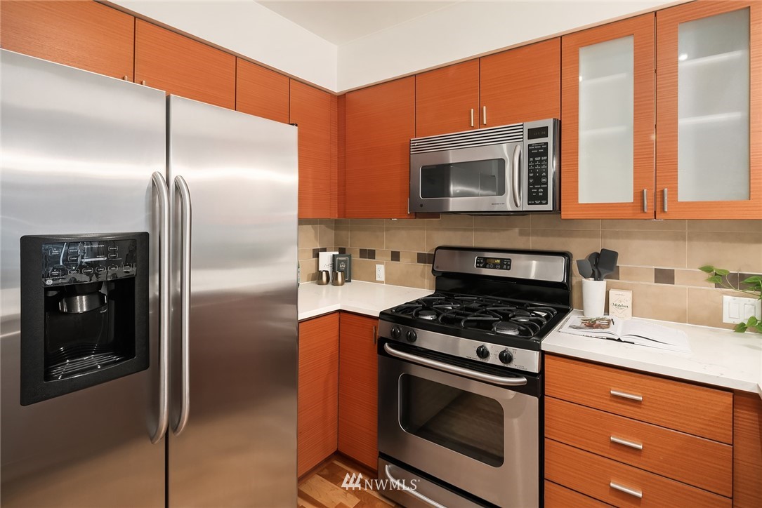 819 Virginia Street, Unit 1006 Seattle, WA 98101 - Photo 6 of 20 a kitchen with stainless steel appliances granite countertop a stove a refrigerator and a microwave