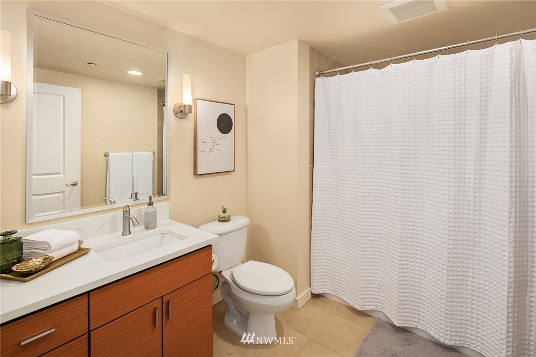 819 Virginia Street, Unit 1006 Seattle, WA 98101 - Photo 9 of 20 a bathroom with a granite countertop sink toilet and shower