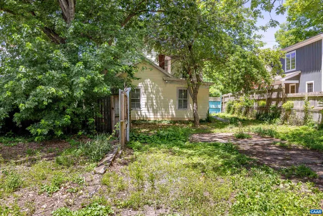 a view of a yard in front of a house with large tree