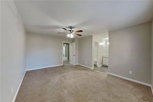 a view of an empty room with a chandelier fan