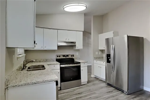 a kitchen with a sink appliances and cabinets