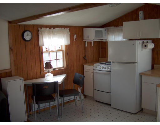 4 A Thompson Road Bourne, MA 02532 - Photo 4 of 9 a kitchen with a refrigerator and table chairs