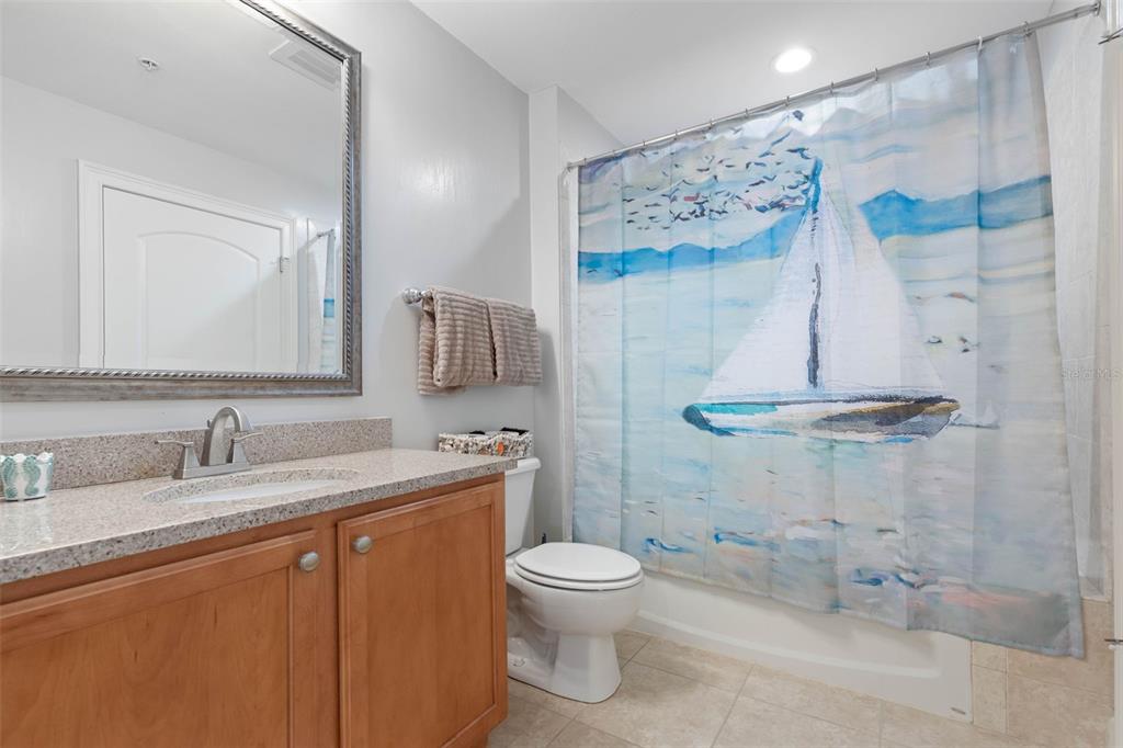 102 Yacht Harbor Drive, Unit 567 Palm Coast, FL 32137 - Photo 34 of 59 a bathroom with a granite countertop sink toilet a mirror and shower