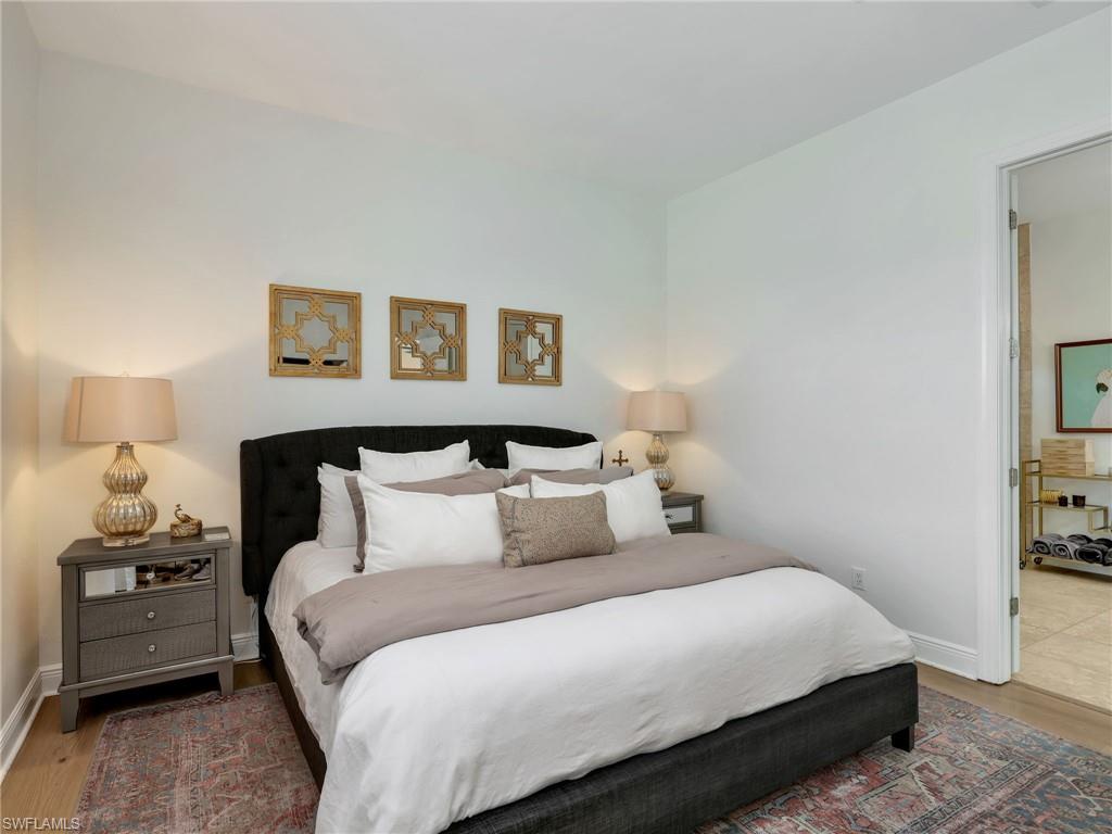 4743 Abaca Circle Naples, FL 34119 - Photo 22 of 50 Bedroom with wood finished floors and ensuite bathroom