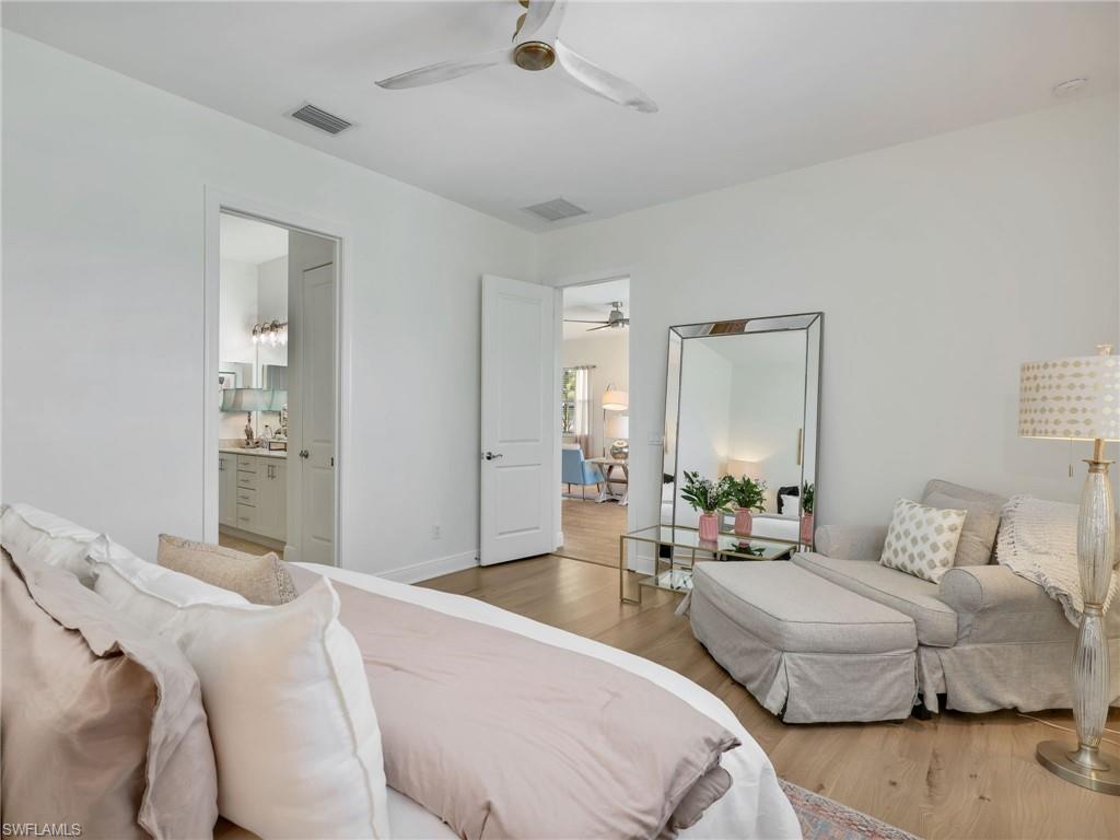4743 Abaca Circle Naples, FL 34119 - Photo 22 of 50 Bedroom featuring wood finished floors, ceiling fan, and ensuite bathroom