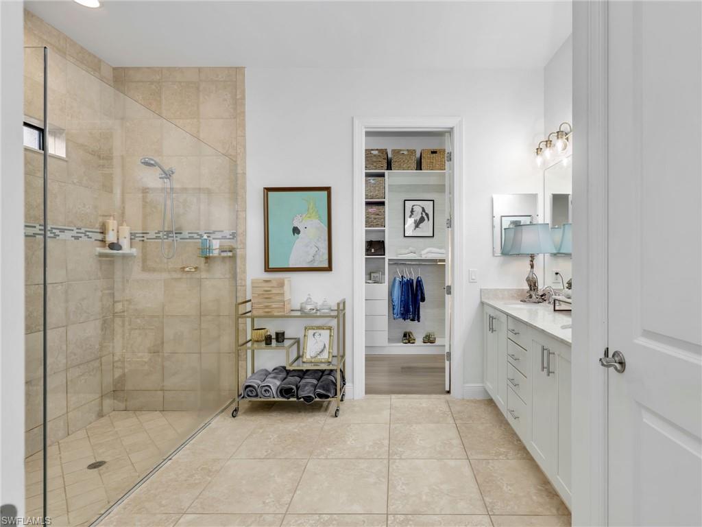 4743 Abaca Circle Naples, FL 34119 - Photo 23 of 50 Full bath featuring vanity, walk in shower, light tile patterned floors, and a spacious closet