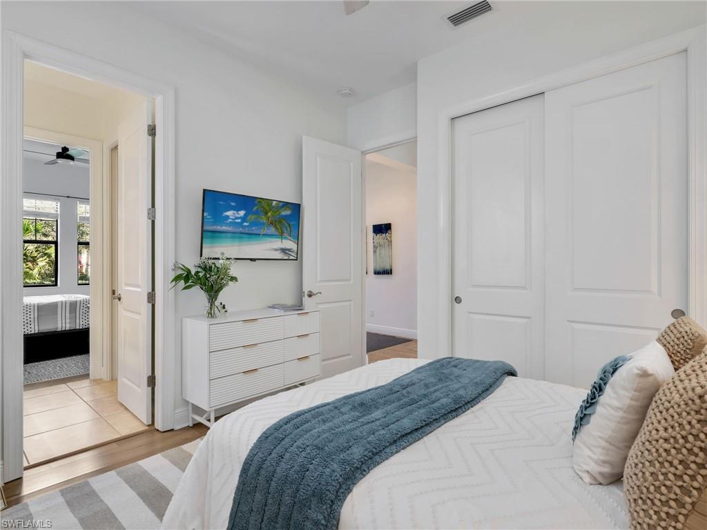 4743 Abaca Circle Naples, FL 34119 - Photo 30 of 50 Bedroom with a closet, ensuite bathroom, and wood finished floors