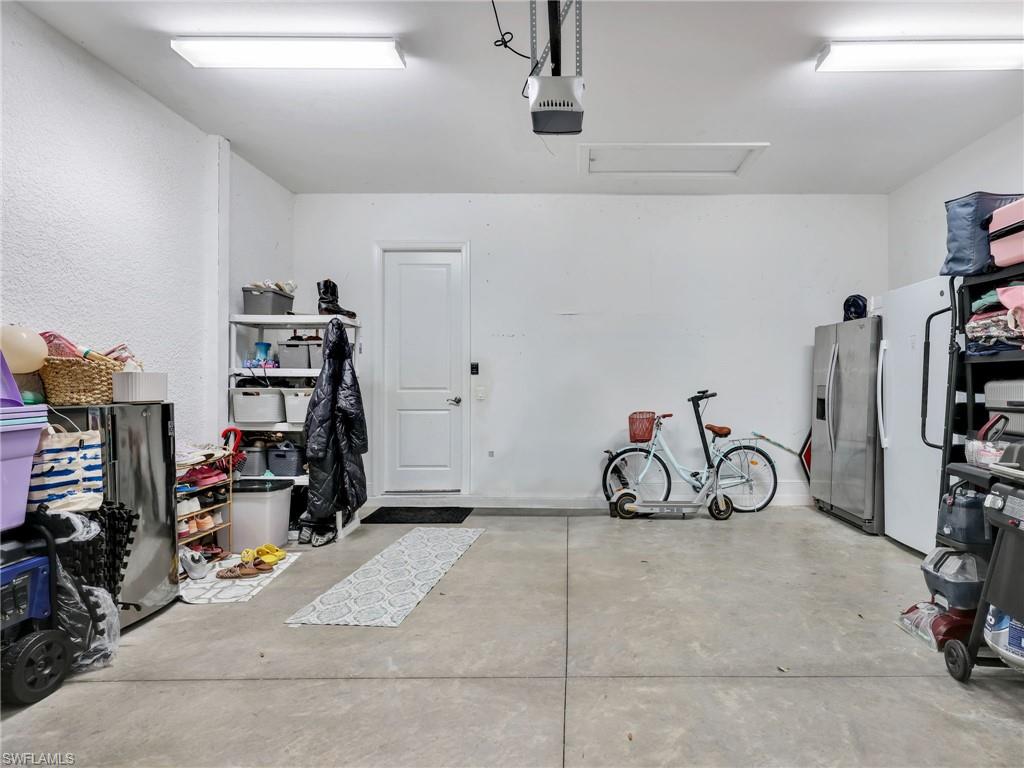 4743 Abaca Circle Naples, FL 34119 - Photo 36 of 50 Garage with stainless steel fridge, freestanding refrigerator, and a garage door opener